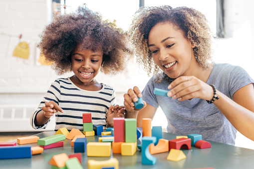 A mom and daughter playing blocks together