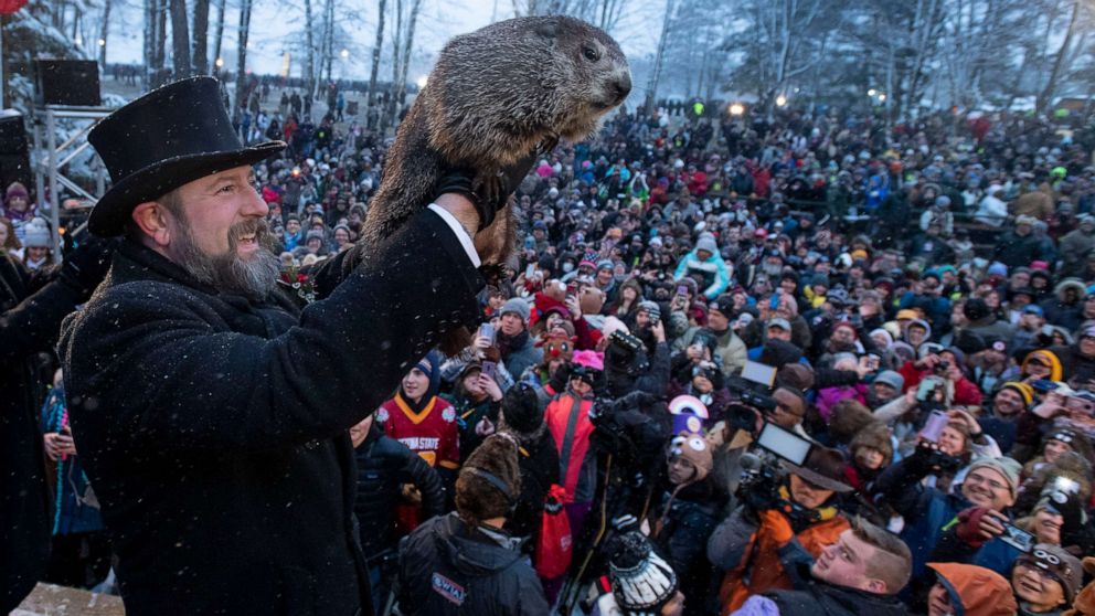 Guy holding up groundhog in front of audience