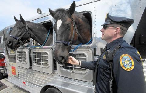 An Bethlehem officer hanging out with two police officers who happen to be horses.