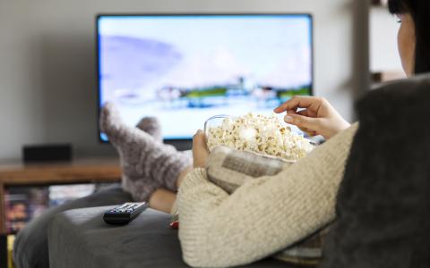 Someone eating popcorn while watching a movie.