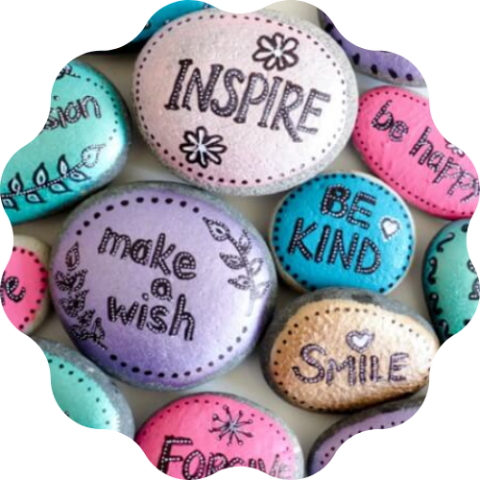 Rocks painted multiple bright colors with kind phrases painted on them