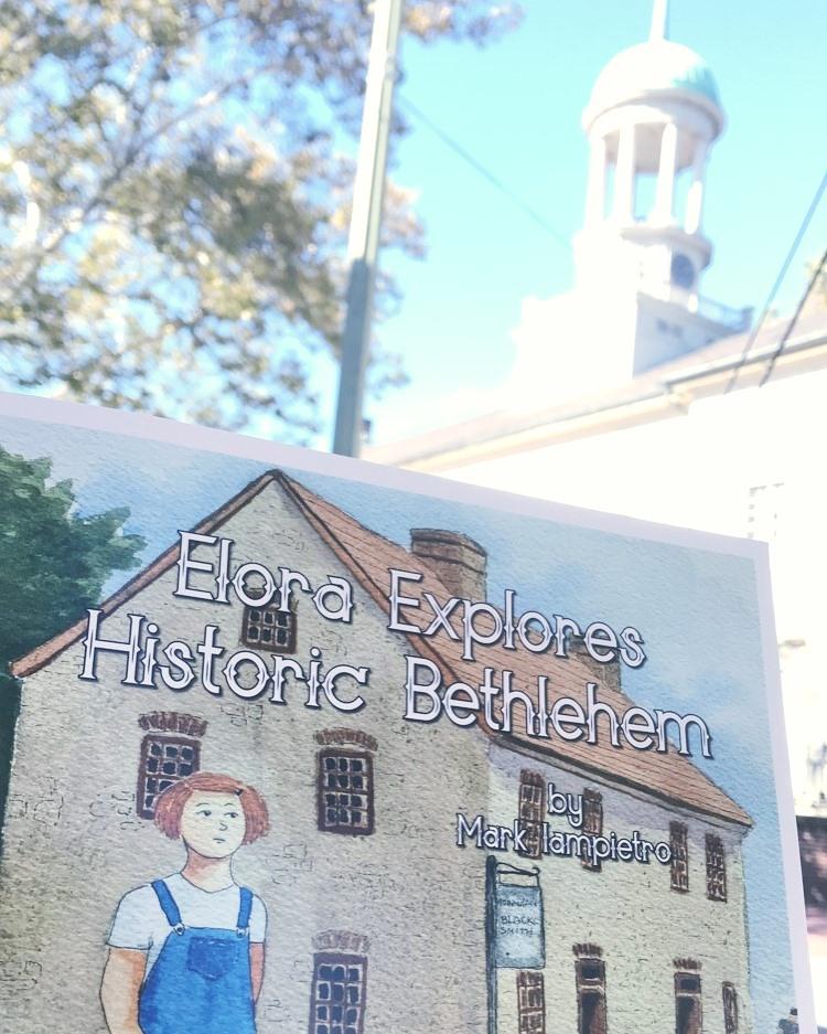 Photo of the Moravian Church and "Elora Explores Historic Bethlehem" book by Mark Iampietro