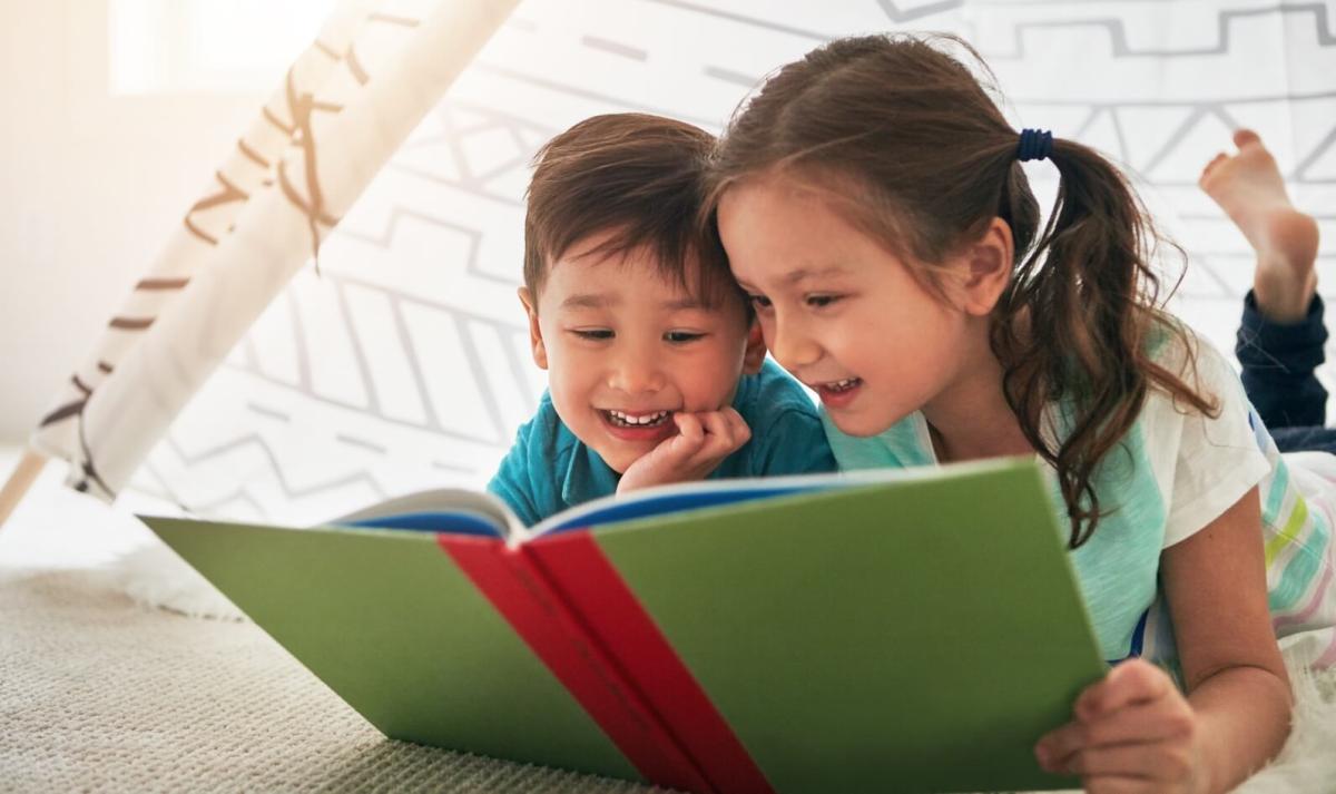 Two kids reading a book